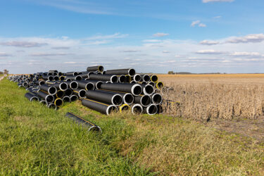 Black plastic field tile pipe in farm field Flooding prevention, soil conservation and drainage concept